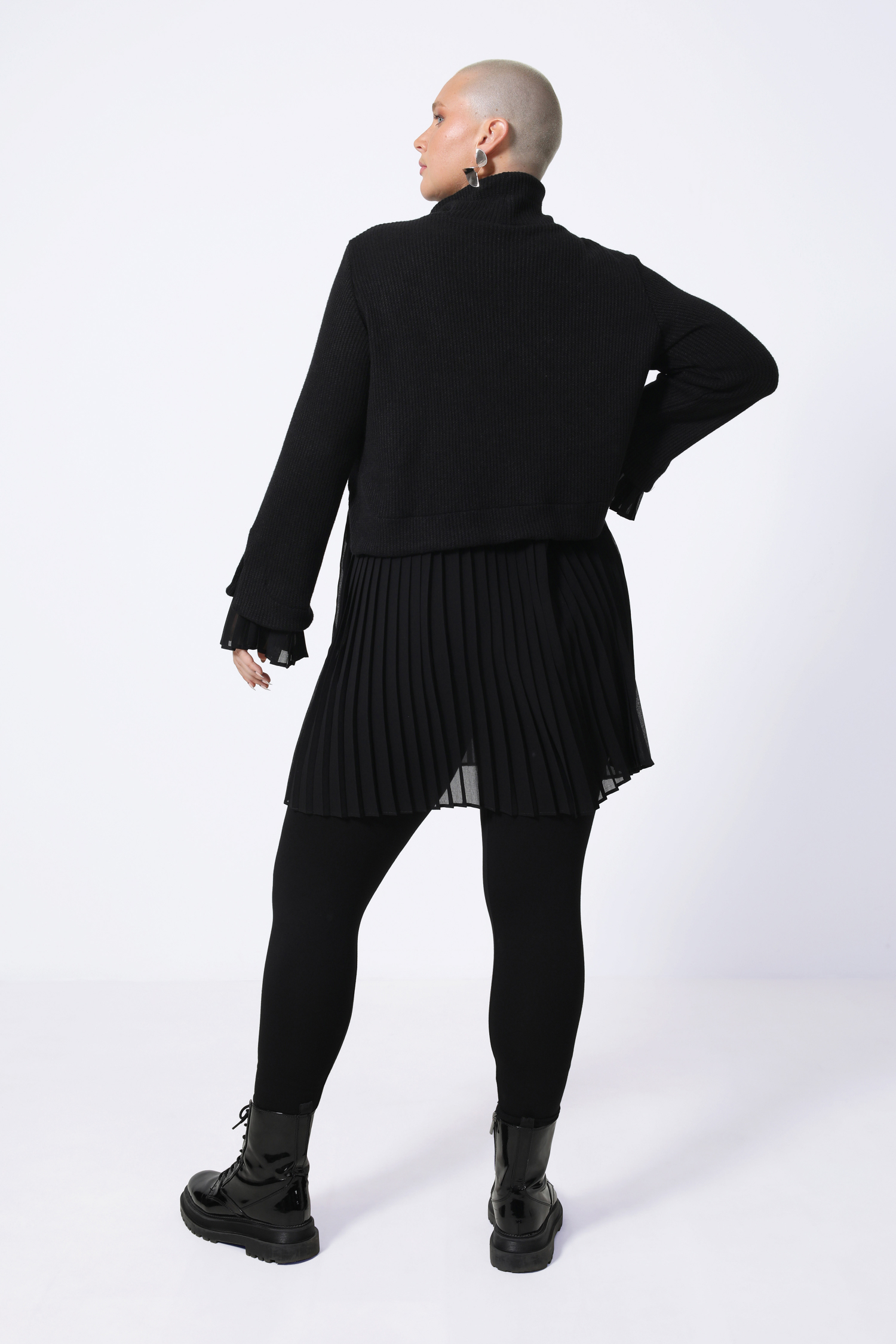 Plain sweater layered over pleated