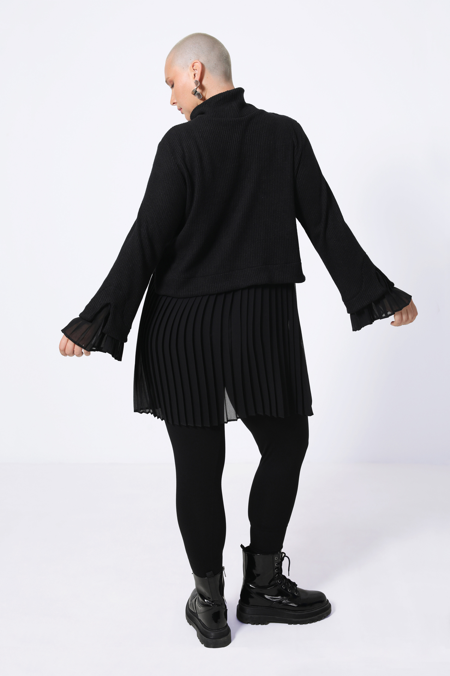 Plain sweater layered over pleated